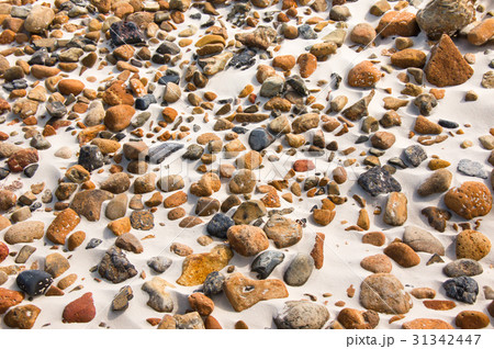 smooth round pebble stones on the sand backgound. 31342447