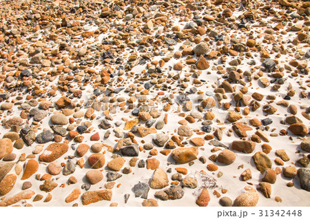 smooth round pebble stones on the sand backgound. 31342448
