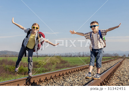 Happy brother and sister walking on the railway at the day time. 31342451