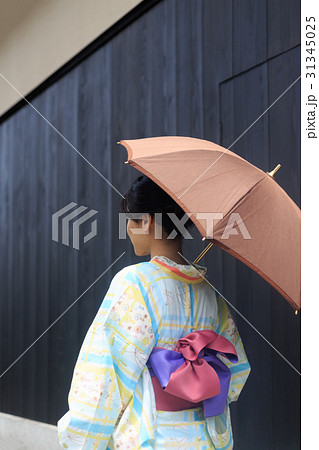 夏のイメージ 日傘をさす浴衣姿の若い女性の写真素材