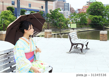 夏のイメージ ベンチに腰掛ける浴衣姿の若い女性の写真素材 [31345536] - PIXTA