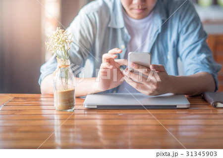 man hand texting on smartphone in cafe man hand texting on smartphone in cafe 31345903