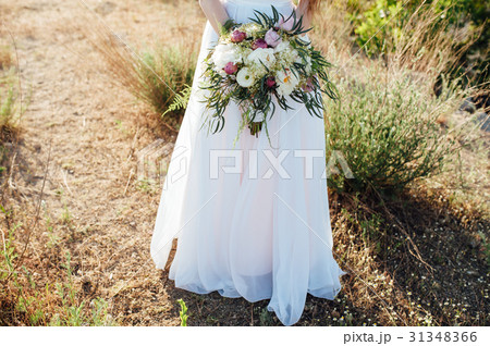 bride in a white dress holding a bouquet 31348366