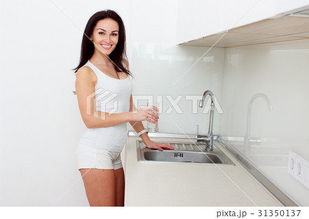 Charming woman holding glass filled with water 31350137