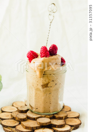 Melts ice cream with raspberries in a glass jar. Melts ice cream with raspberries in a glass jar. 31357095