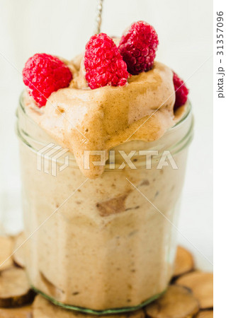 Melts ice cream with raspberries in a glass jar. Melts ice cream with raspberries in a glass jar. 31357096