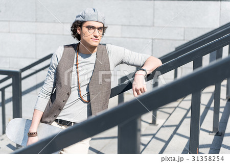 Pensive young male is leaning on handrails Pensive young male is leaning on handrails 31358254