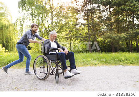 Hipster son running with disabled father in Hipster son running with disabled father in 31358256