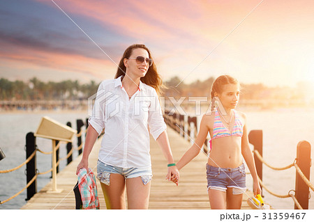 Young woman with her daughter strolling along pier 31359467