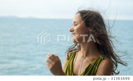 Beautiful dreamy young woman listening to music on 31363699