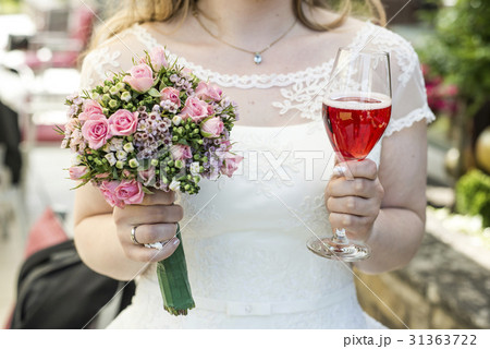 Bride holding bouquet of flowers and a glass of Bride holding bouquet of flowers and a glass of 31363722