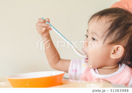 Asian toddler girl eating cereals with milk. Asian toddler girl eating cereals with milk. 31363988