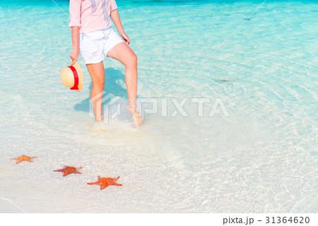 Female feet on white sandy beach. Starfish on the 31364620