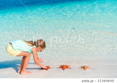 Adorable little girl holding giant red starfish on 31364640