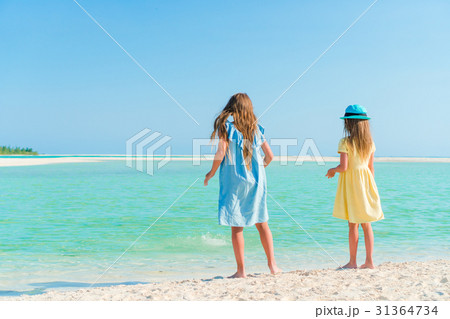 Little girls having fun at tropical beach playing Little girls having fun at tropical beach playing 31364734