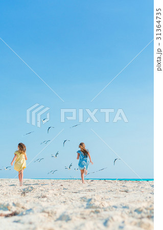 Little girls having fun at tropical beach playing Little girls having fun at tropical beach playing 31364735