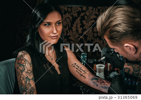 Professional tattoo artist makes a tattoo on a 31365069