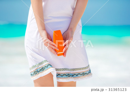 Closeup suncream bottle in female hands on the Closeup suncream bottle in female hands on the 31365123