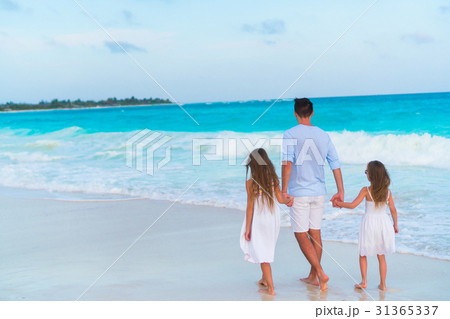 Family walking on white beach on caribbean island 31365337