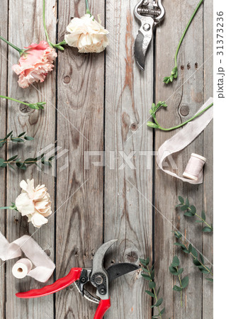 The florist work table with tools on gray wooden The florist work table with tools on gray wooden 31373236