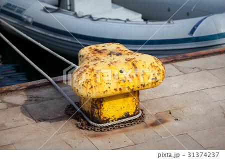 Old yellow bollard in the port Old yellow bollard in the port 31374237
