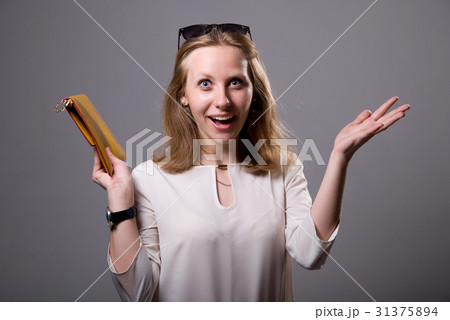 Portrait of a surprised girl in sunglasses holding 31375894