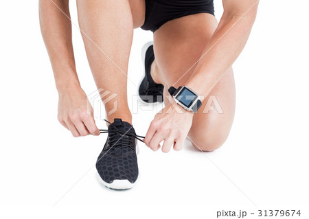 Female athlete tying her shoelace Female athlete tying her shoelace 31379674