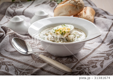 Sorrel soup with egg in white bowl. 31381674