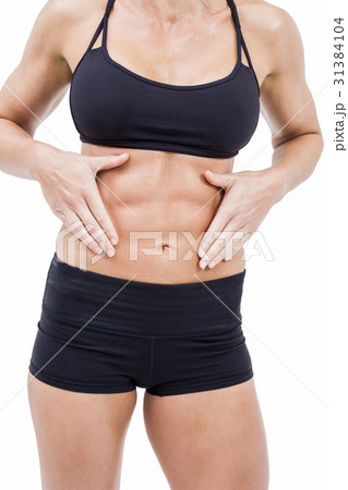 Female athlete touching her abs Female athlete touching her abs 31384104