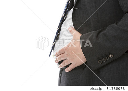 お腹に手をあてるスーツ姿の男性の写真素材