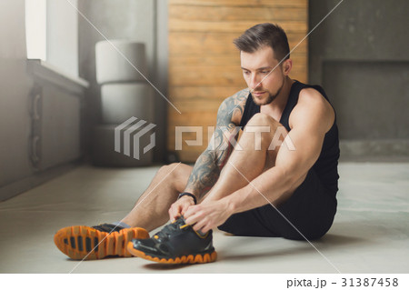 Handsome young man lace shoes at gym after Handsome young man lace shoes at gym after 31387458