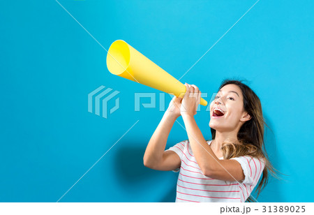 Young woman holding a paper megaphone Young woman holding a paper megaphone 31389025
