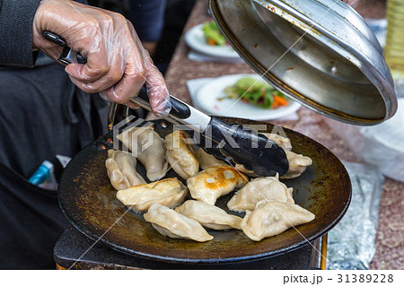 Dumplings frying on grill pan on food stall. 31389228