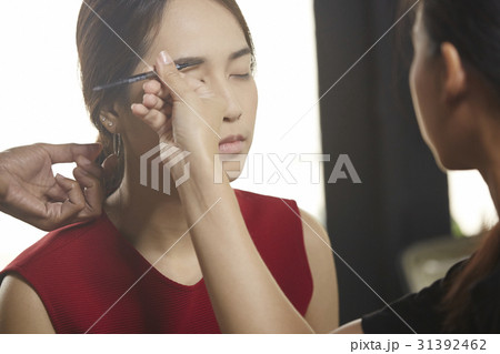 a woman is made up before the photo-shoot. 31392462