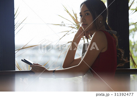 a woman is thinking something near by a window. a woman is thinking something near by a window. 31392477