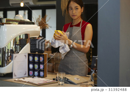 a woman is standing and cleaning something. a woman is standing and cleaning something. 31392488