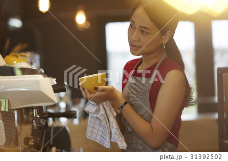 a woman is looking something when holding a cup. a woman is looking something when holding a cup. 31392502