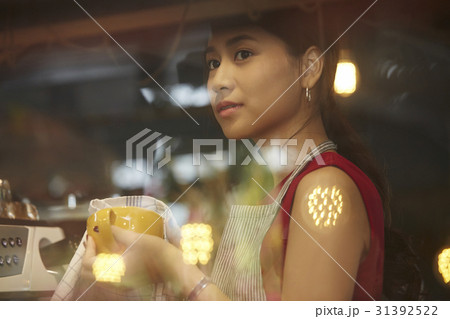 a staff of café is cleaning a cup when she thinks something. 31392522