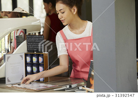 a waitress is arranging the menu before opening hours. 31392547