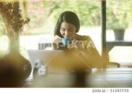 a businesswoman is enjoying a cup of coffee in the café. 31392559