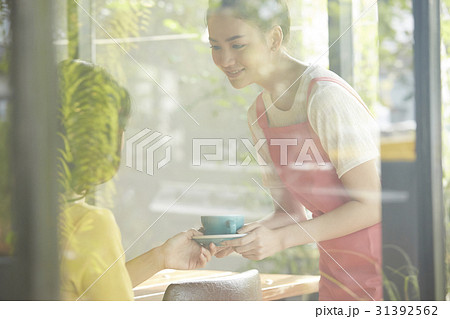 a waitress is bringing a cup of coffee for the customer. 31392562