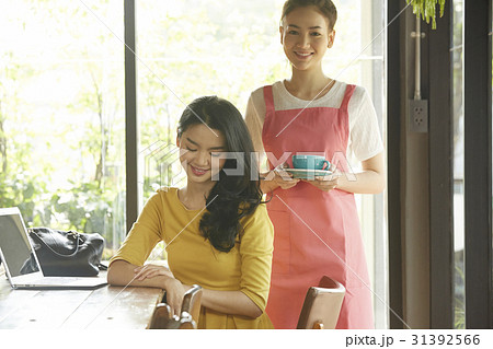 A photo of beautiful woman and a young waitress in the café. 31392566