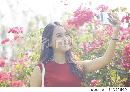 Young woman is taking selfie in a beautiful garden Young woman is taking selfie in a beautiful garden 31392699