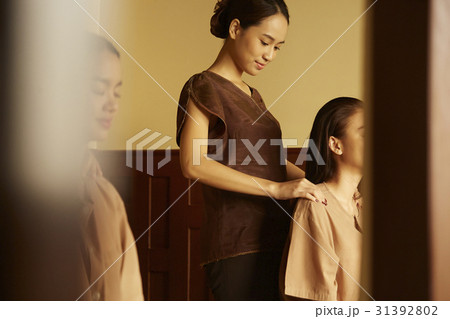 Two women are getting shoulder massage by spa therapist. 31392802