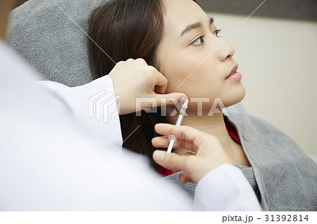 A doctor is injecting botox into a girl's face. A doctor is injecting botox into a girl's face. 31392814