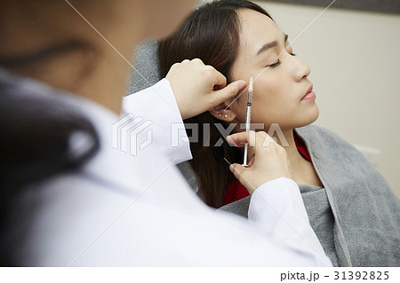 A photo of someone injecting botox into woman's face. A photo of someone injecting botox into woman's face. 31392825
