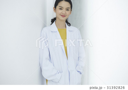 A doctor standing against the wall is looking at camera. A doctor standing against the wall is looking at camera. 31392826