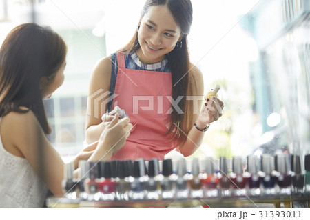a happy girl is asking the female seller about some lacquer 31393011