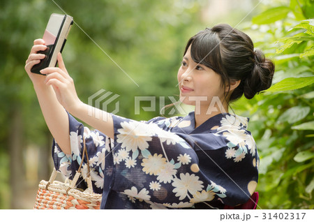 自撮りする浴衣の女性の写真素材