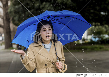 雨の降る街頭をリポートする女子アナ 雨の降る街頭をリポートする女子アナ 31402489